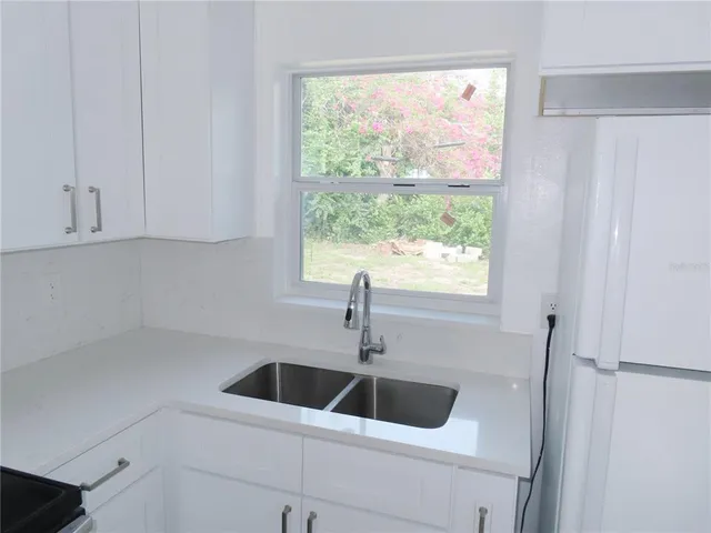 a kitchen with a sink and large window