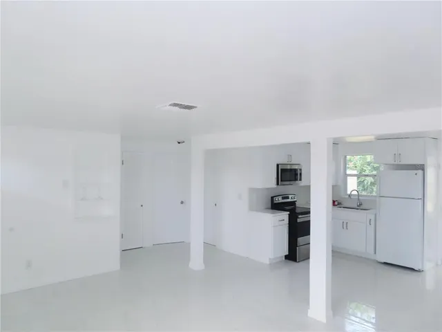 a view of a kitchen with a refrigerator a stove top oven and a refrigerator