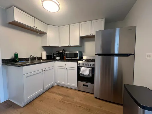 a kitchen with a refrigerator sink and cabinets