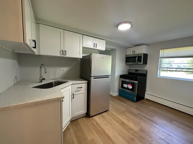 a kitchen with a refrigerator sink and cabinets