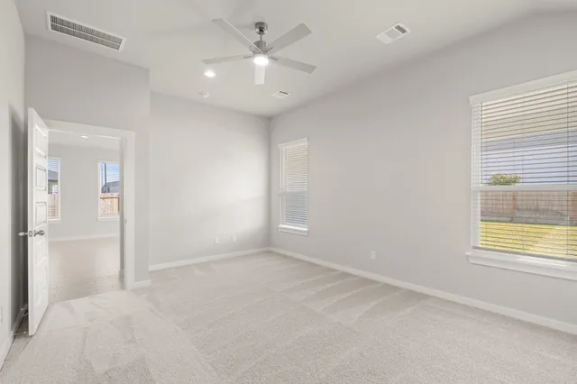 an empty room with a window and a ceiling fan