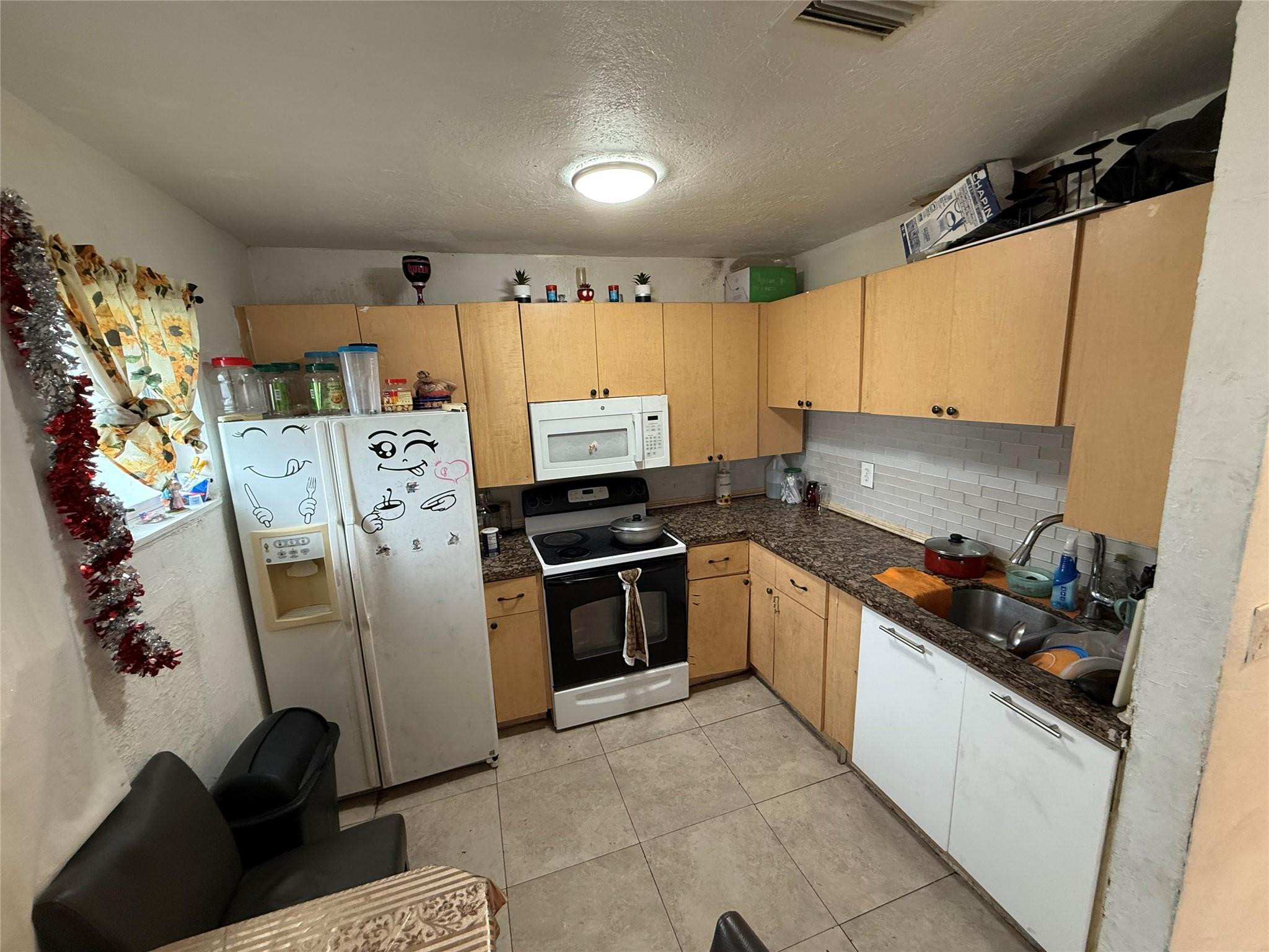 1028 Northwest 24th Street Miami, FL 33127 - Photo 14 of 24 a kitchen with a refrigerator and cabinets
