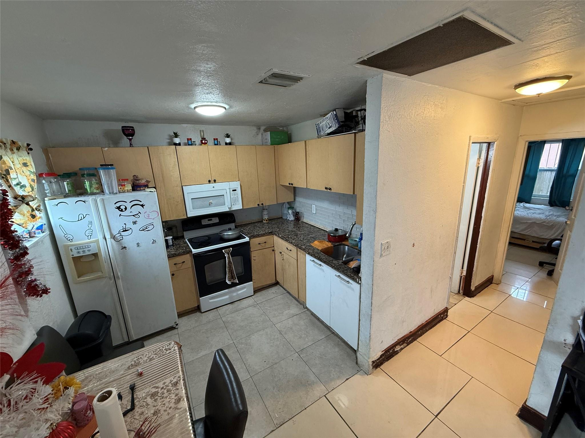 1028 Northwest 24th Street Miami, FL 33127 - Photo 15 of 24 a kitchen with stainless steel appliances a refrigerator a sink a stove top oven a washer and dryer