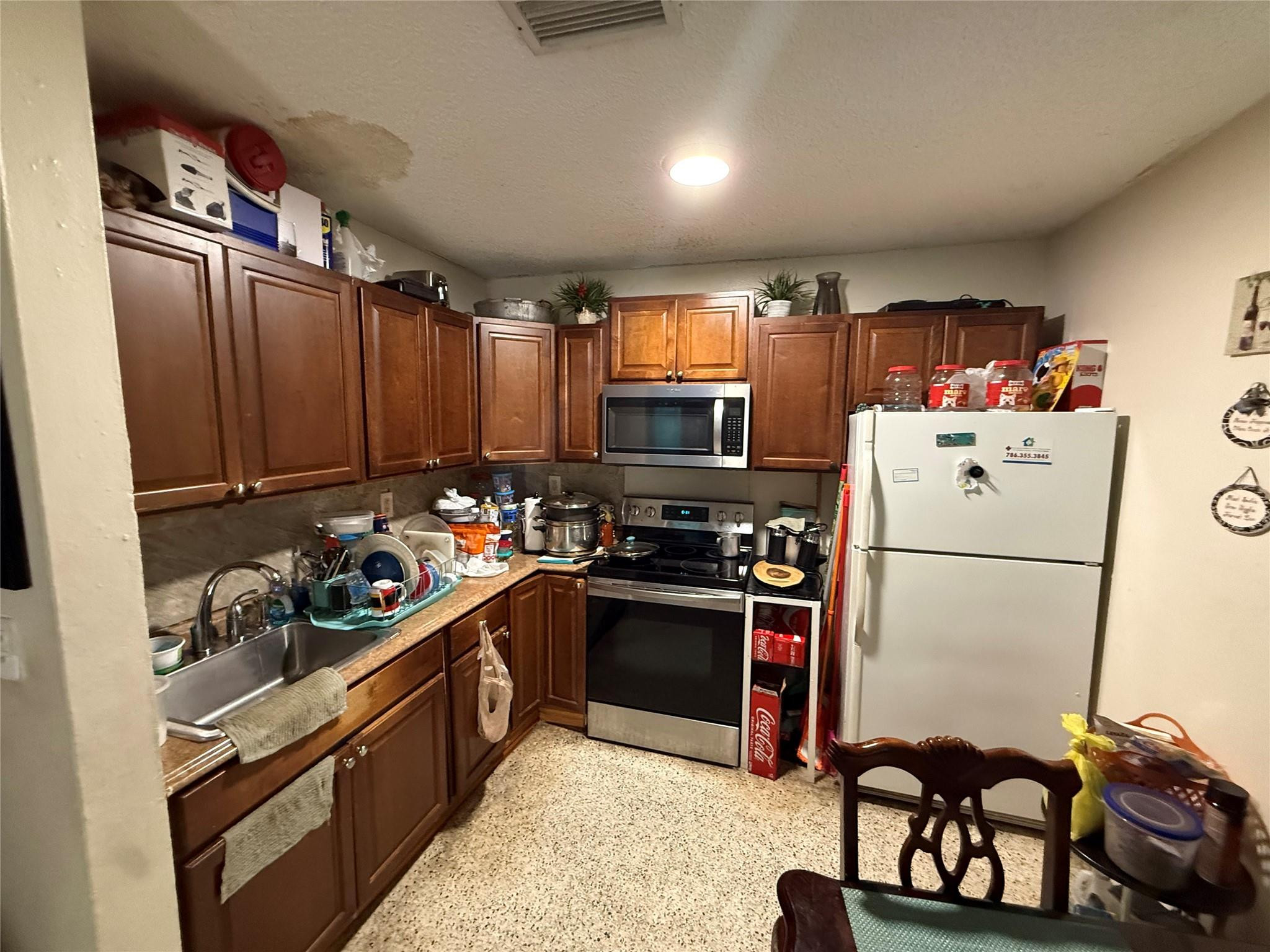 1028 Northwest 24th Street Miami, FL 33127 - Photo 3 of 24 a kitchen with refrigerator a stove a sink and a cabinets