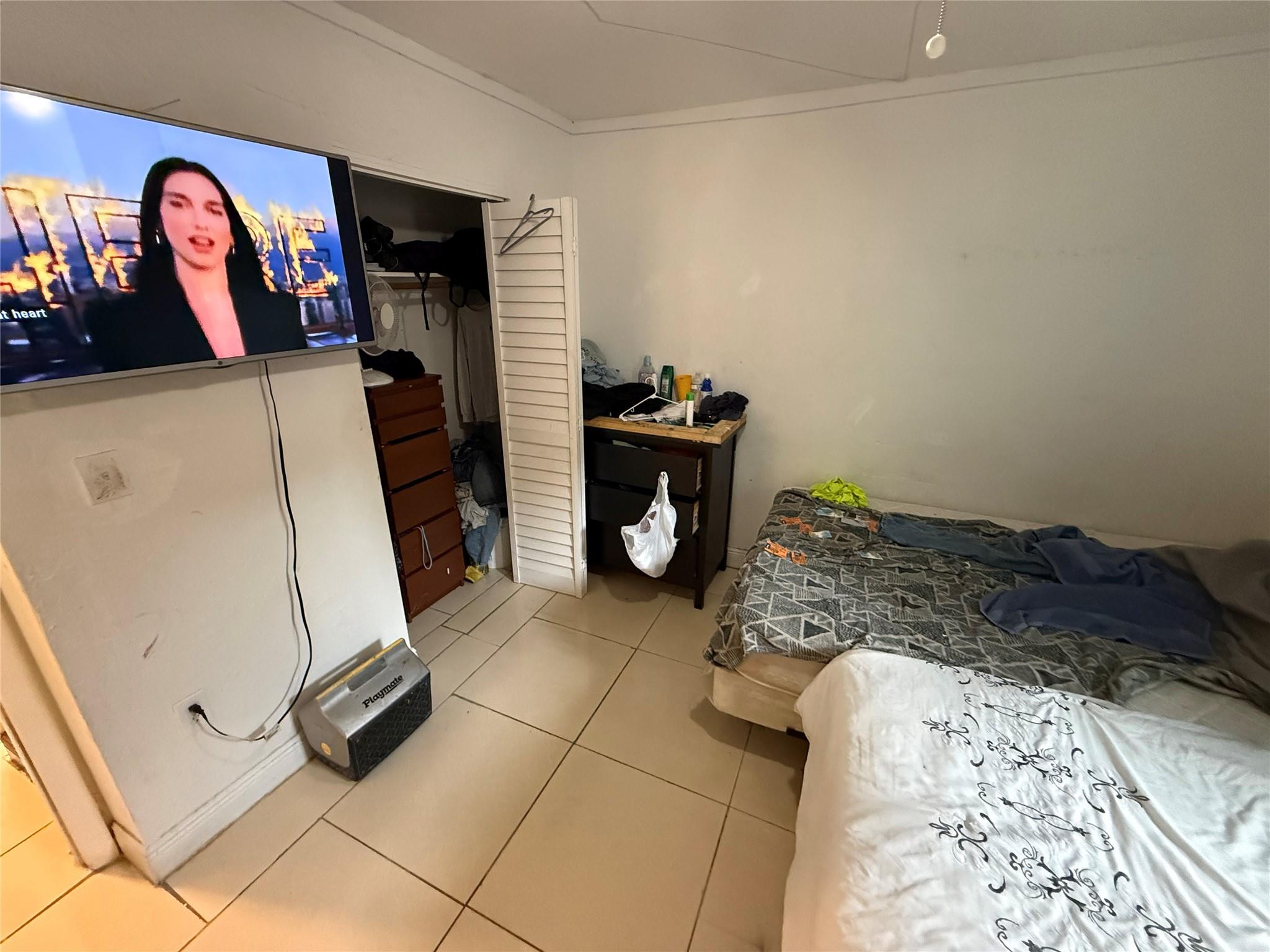 1028 Northwest 24th Street Miami, FL 33127 - Photo 6 of 24 a bed room with a bed and a television