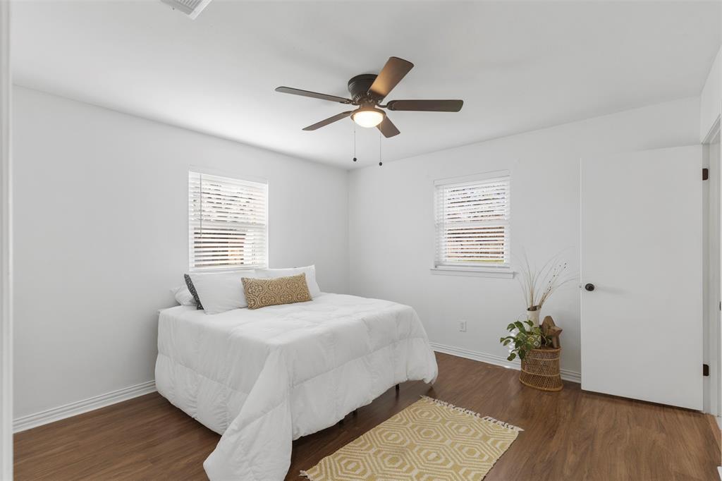 708 East Prairie View Road Crowley, TX 76036 - Photo 15 of 21 Bright room featuring wood-finish flooring, two windows with blinds, a ceiling fan with integrated lighting, and white walls