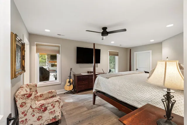 a spacious bedroom with a bed and a flat screen tv