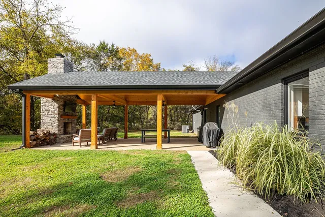 a view of a patio with a table and chairs under an umbrella