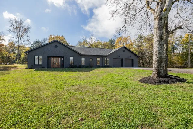 a front view of a house with yard and green space
