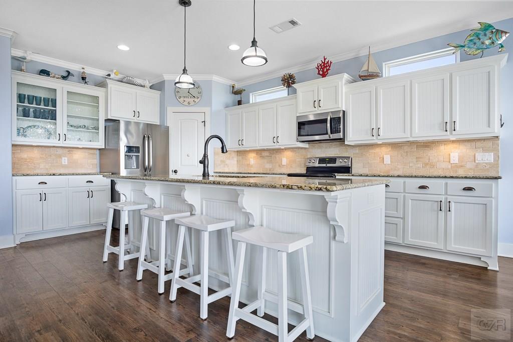 437 Atkinson Street Crystal Beach, TX 77650 - Photo 13 of 40 a kitchen with granite countertop white cabinets and stainless steel appliances