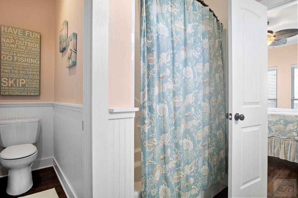 437 Atkinson Street Crystal Beach, TX 77650 - Photo 14 of 40 a white toilet sitting next to a shower curtain
