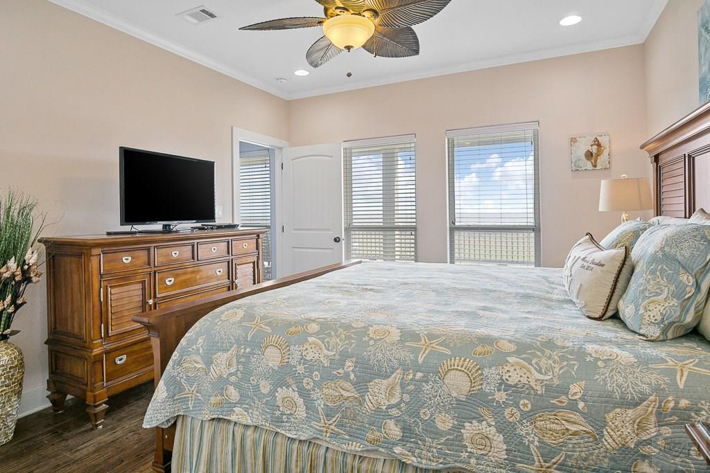 437 Atkinson Street Crystal Beach, TX 77650 - Photo 15 of 40 a bedroom with a bed and a flat tv screen on dresser
