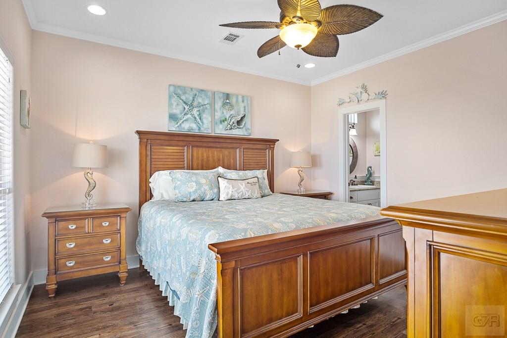 437 Atkinson Street Crystal Beach, TX 77650 - Photo 17 of 40 a bedroom with a bed and wooden floor