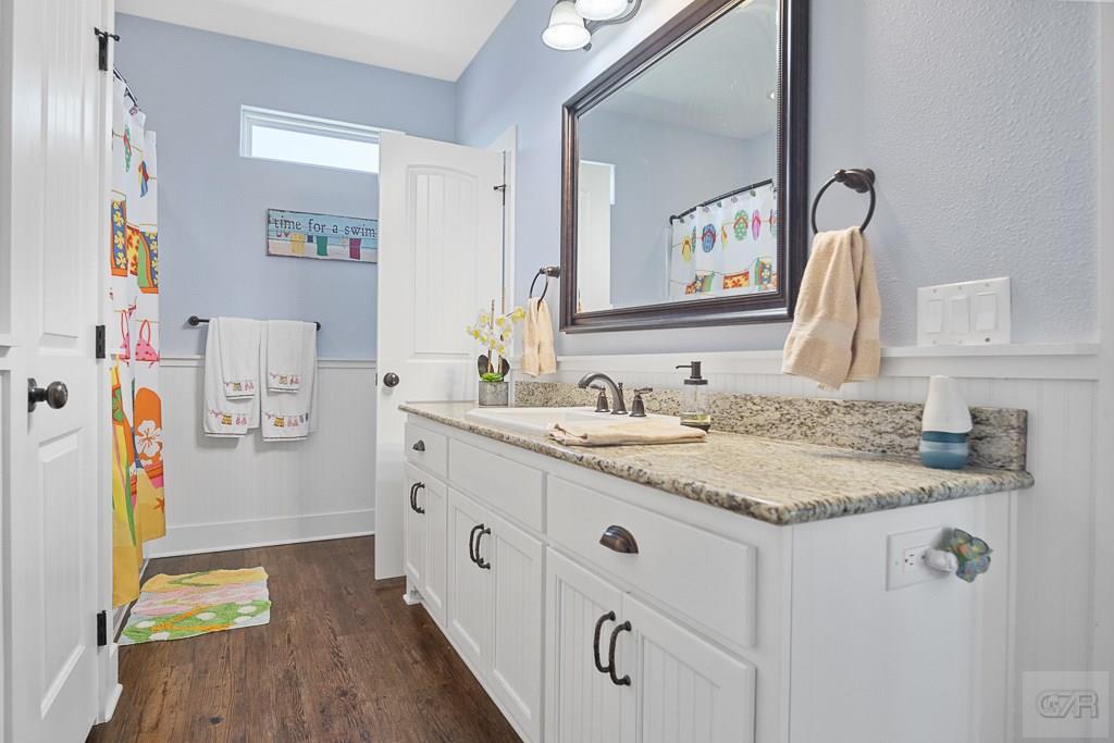 437 Atkinson Street Crystal Beach, TX 77650 - Photo 22 of 40 a bathroom with a granite countertop sink and a mirror