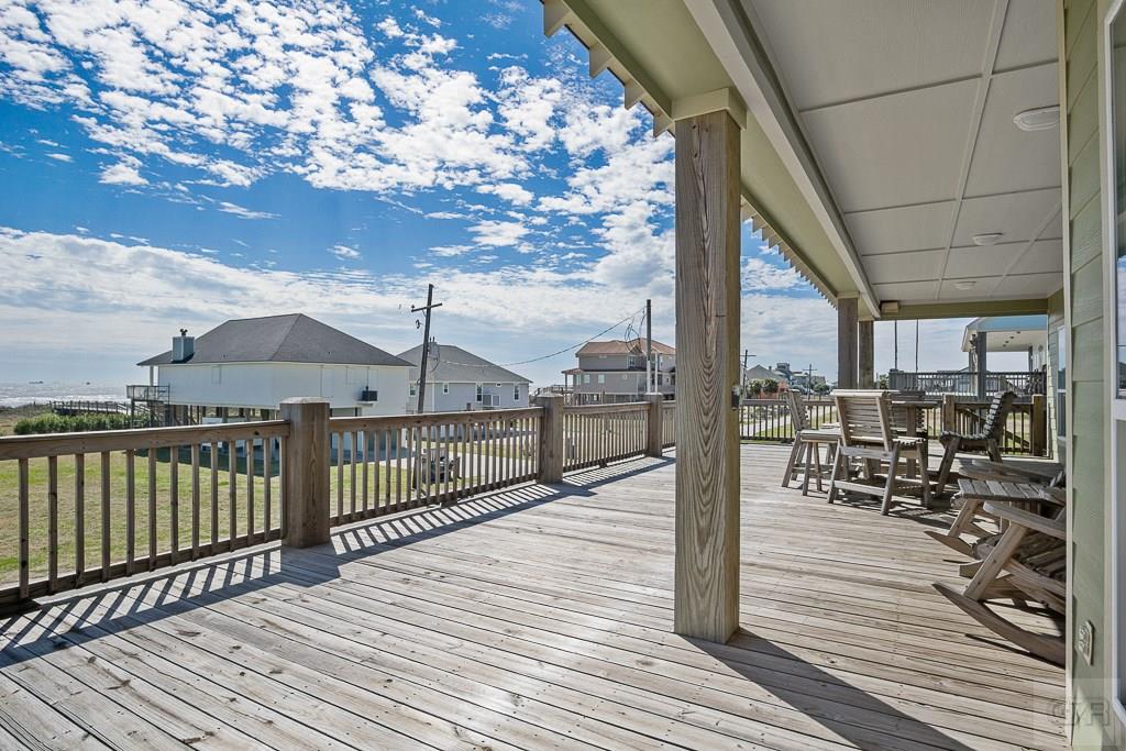 437 Atkinson Street Crystal Beach, TX 77650 - Photo 27 of 40 a view of a balcony with wooden floor next to a yard