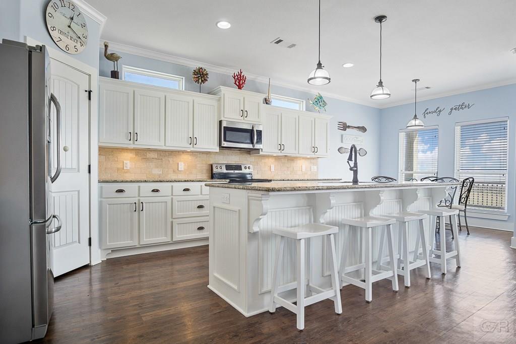 437 Atkinson Street Crystal Beach, TX 77650 - Photo 5 of 40 a kitchen with granite countertop a sink cabinets and stainless steel appliances