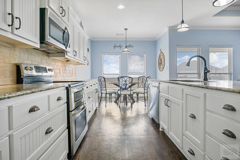 437 Atkinson Street Crystal Beach, TX 77650 - Photo 7 of 40 a kitchen with white cabinets and sink