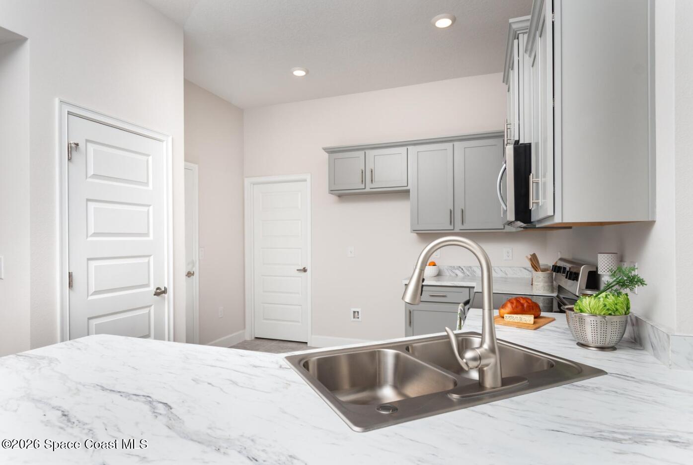 1361 Tupelo Circle Cocoa, FL 32926 - Photo 3 of 7 a kitchen with stainless steel appliances granite countertop a sink stove and cabinets