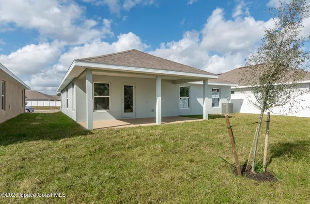 a view of a big house with a big yard and large tree