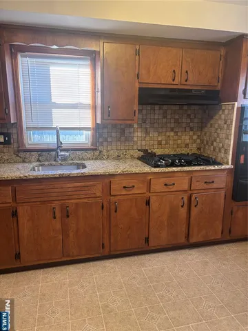 a kitchen with granite countertop a sink and a stove