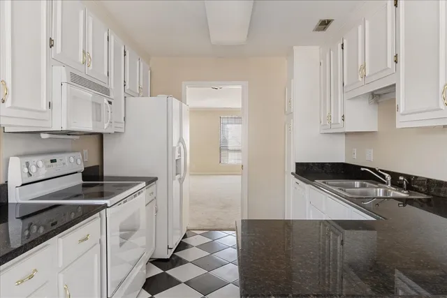 a kitchen with granite countertop a sink stove and refrigerator