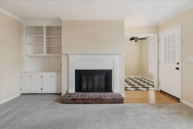 a view of an empty room with a fireplace and a window