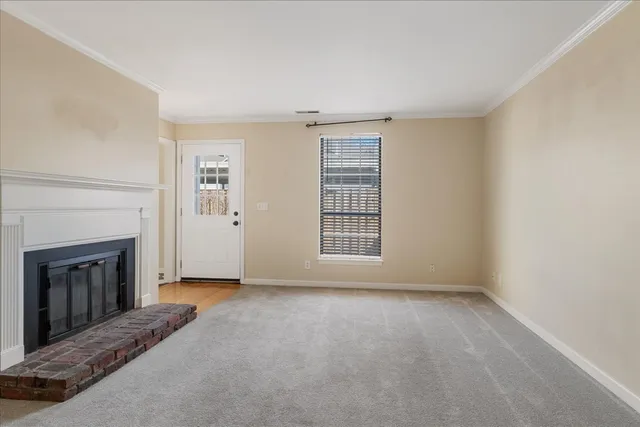 a view of an empty room with a fireplace and a window