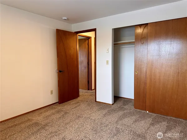 an empty room with closet and wooden floor