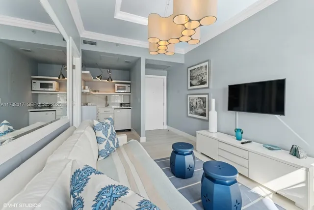 a living room with furniture a flat screen tv and kitchen view