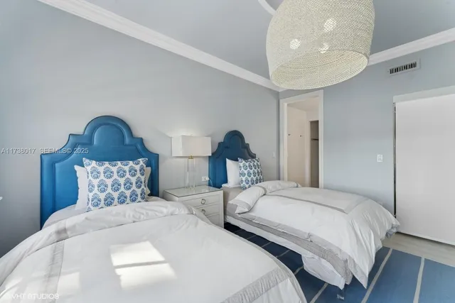 a bedroom with two beds and a painting on the wall