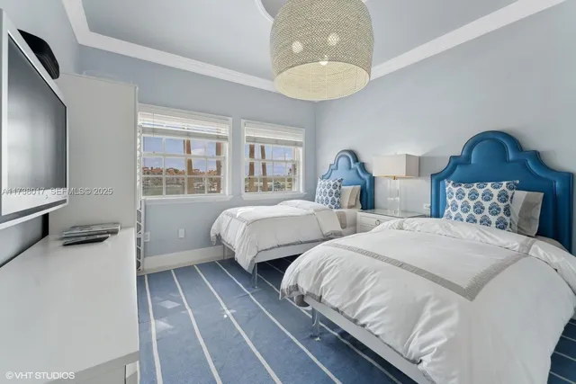 a bedroom with two beds and a flat screen tv