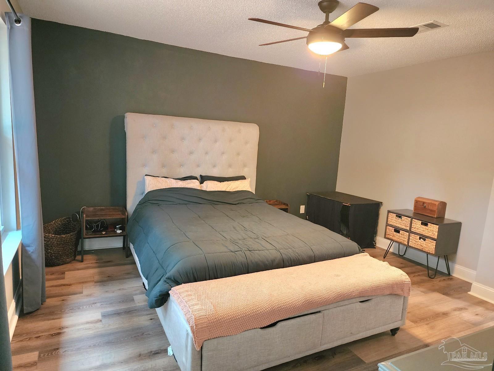 4348 Wellington Drive Pace, FL 32571 - Photo 12 of 20 a bedroom with a bed a chair and a potted plant on a dresser
