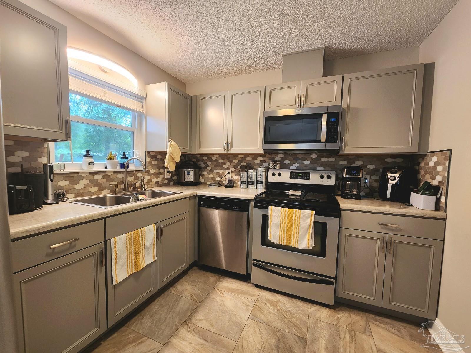 4348 Wellington Drive Pace, FL 32571 - Photo 8 of 20 a kitchen with stainless steel appliances granite countertop a stove a sink and a microwave