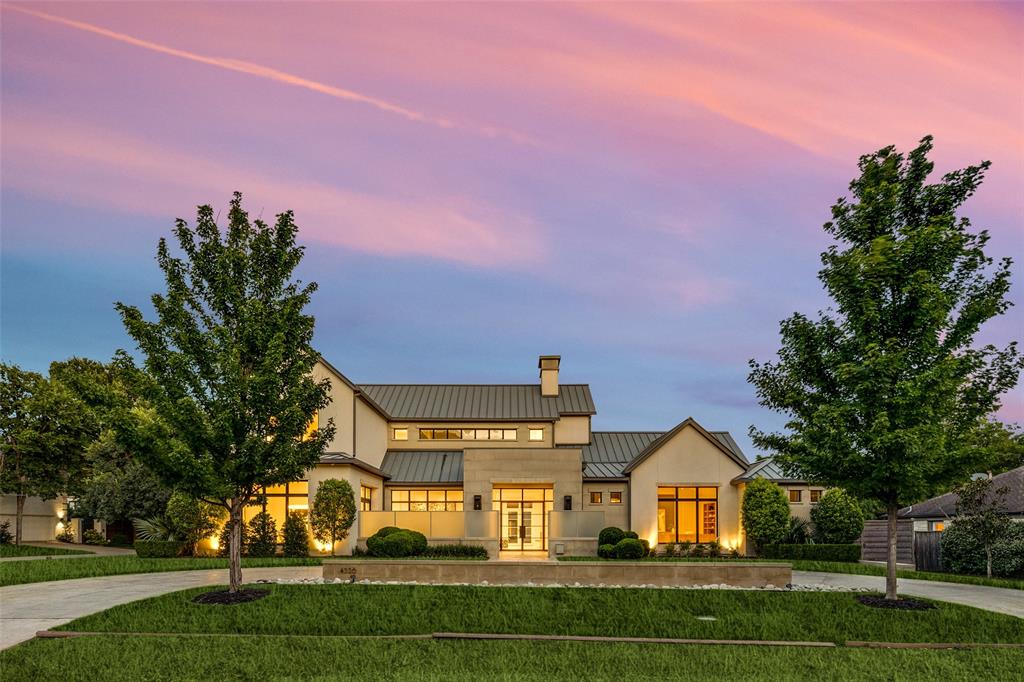 View of front of house featuring a standing seam roof, a metal roof, a chimney, concrete driveway, and a front yard