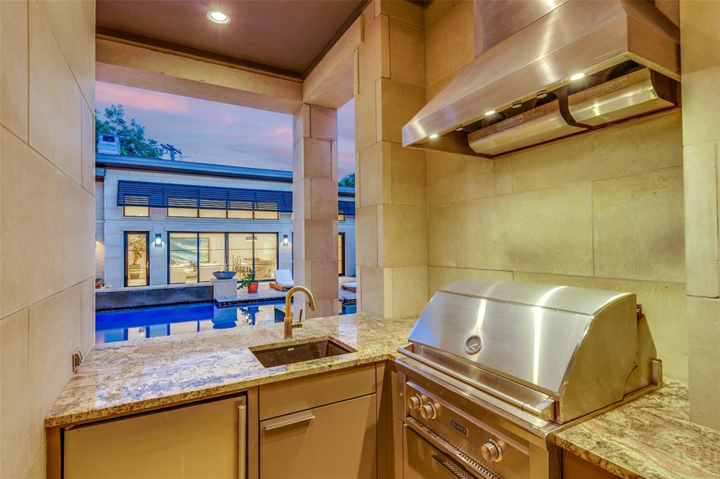 4326 Pomona Road Dallas, TX 75209 - Photo 25 of 31 Kitchen with wall chimney range hood and light stone countertops