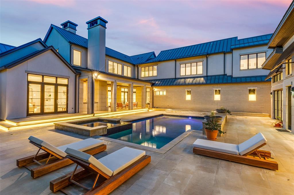 4326 Pomona Road Dallas, TX 75209 - Photo 28 of 31 Back of house at dusk featuring a standing seam roof, a metal roof, a patio area, a pool with connected hot tub, and a chimney
