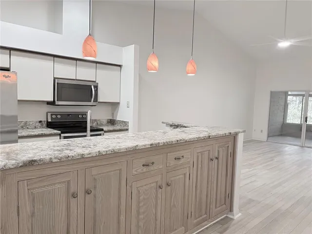 a kitchen with granite countertop a sink a microwave and wooden floor