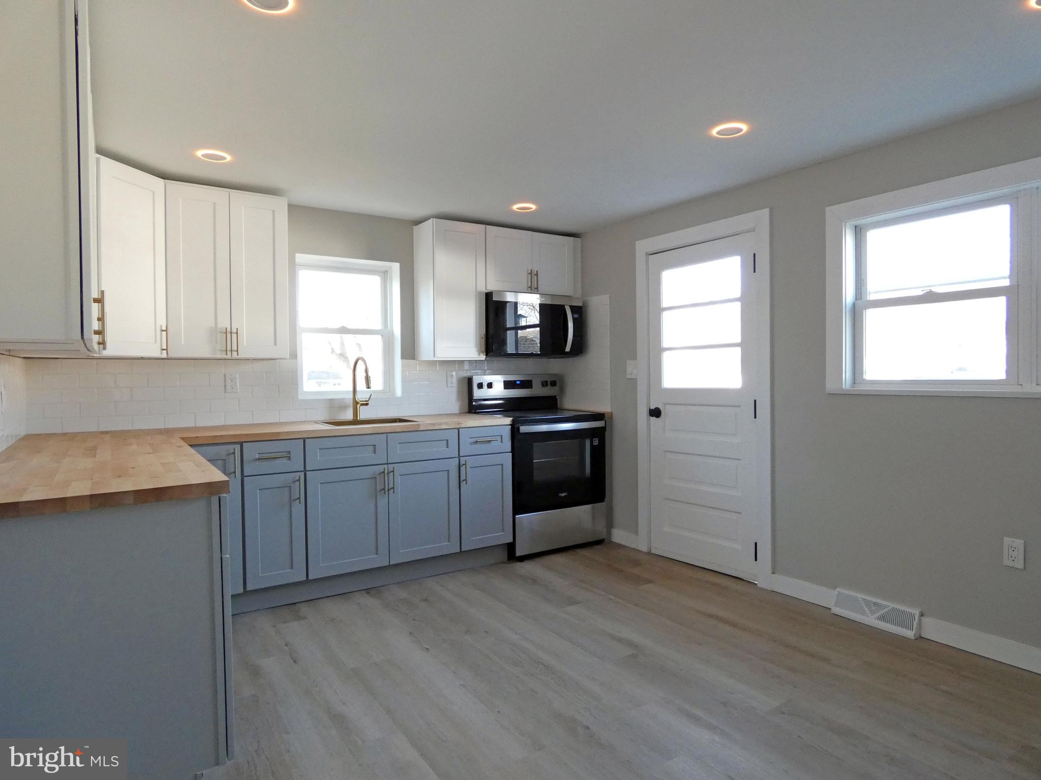 411 Manor Avenue Carneys Point, NJ 08069 - Photo 14 of 50 a kitchen with granite countertop a refrigerator and a stove top oven