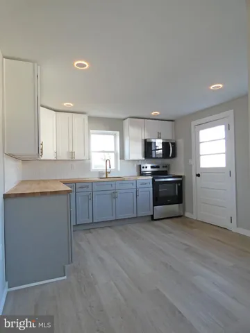 a kitchen with sink a microwave and cabinets
