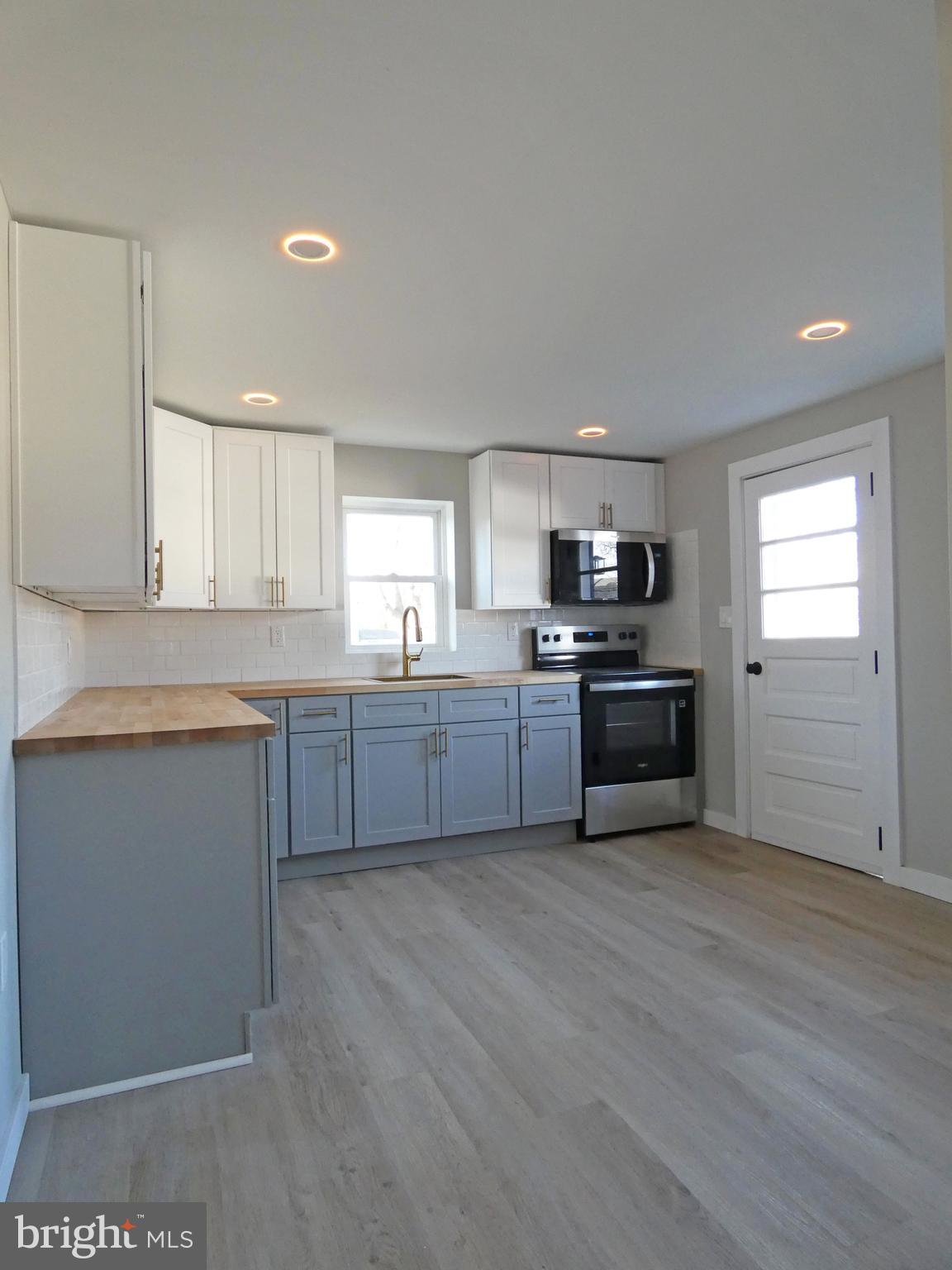 411 Manor Avenue Carneys Point, NJ 08069 - Photo 15 of 50 a kitchen with sink a microwave and cabinets