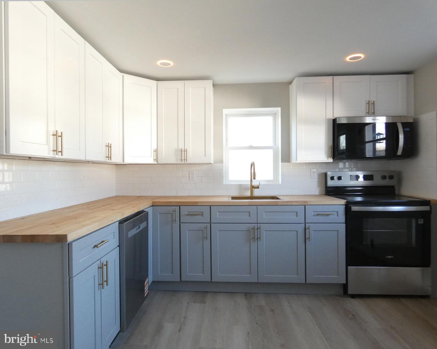 411 Manor Avenue Carneys Point, NJ 08069 - Photo 17 of 50 a kitchen with stainless steel appliances granite countertop a stove a sink and a microwave
