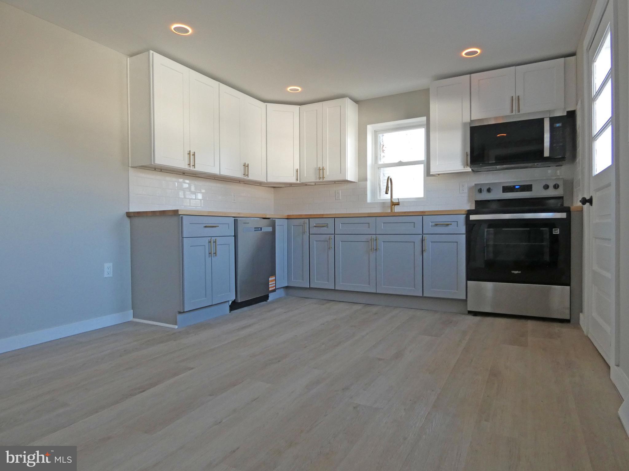 411 Manor Avenue Carneys Point, NJ 08069 - Photo 18 of 50 a kitchen with stainless steel appliances granite countertop a stove a sink and a microwave