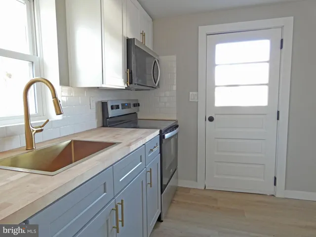 a view of a kitchen sink with a microwave