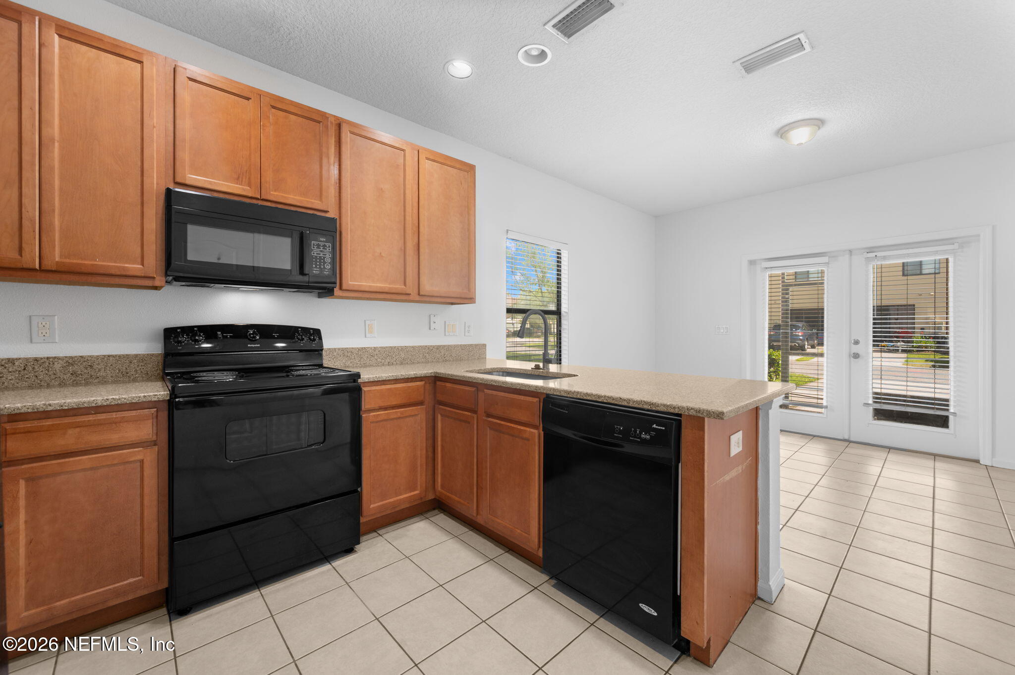 253 Syrah Way St. Augustine, FL 32084 - Photo 10 of 39 a kitchen with stainless steel appliances granite countertop a stove a sink and a microwave