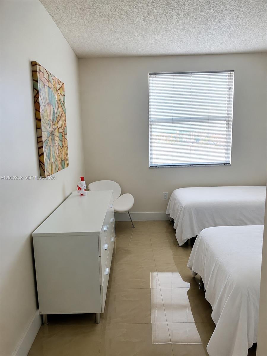 17100 North Bay Road, Unit 1605 Sunny Isles Beach, FL 33160 - Photo 18 of 52 a bedroom with a bed and a night stand