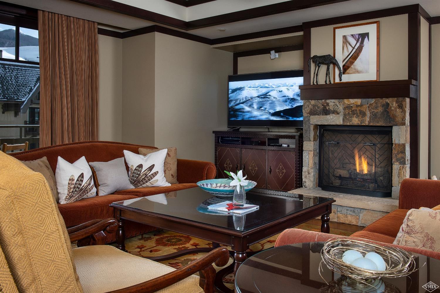 1 Vail Road, Unit 6101 Vail, CO 81657 - Photo 3 of 23 a living room with furniture a flat screen tv and a fireplace