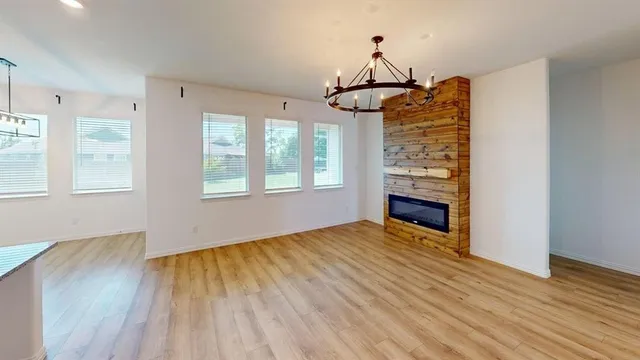a view of empty room with wooden floor and fireplace