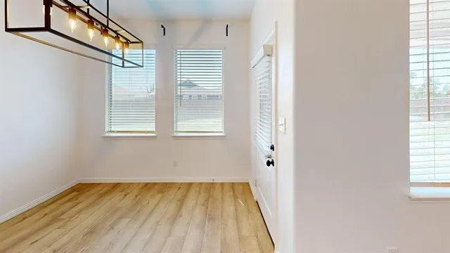 a view of a room with wooden floor and windows