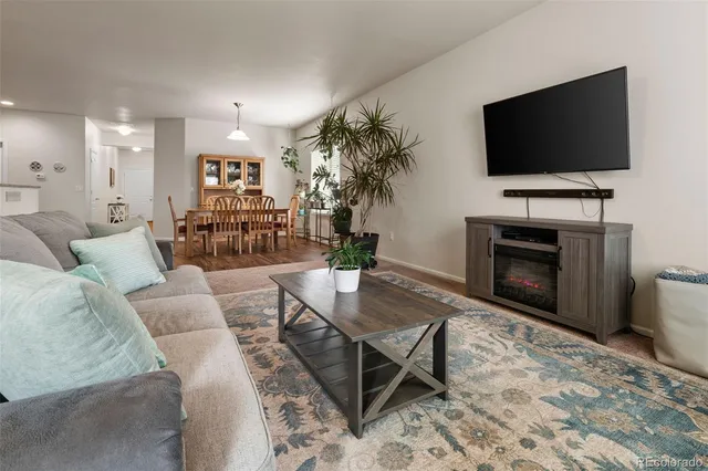 a living room with furniture a flat screen tv and a fireplace