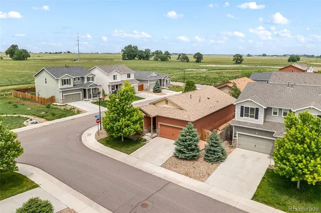 an aerial view of a house with garden space and street view